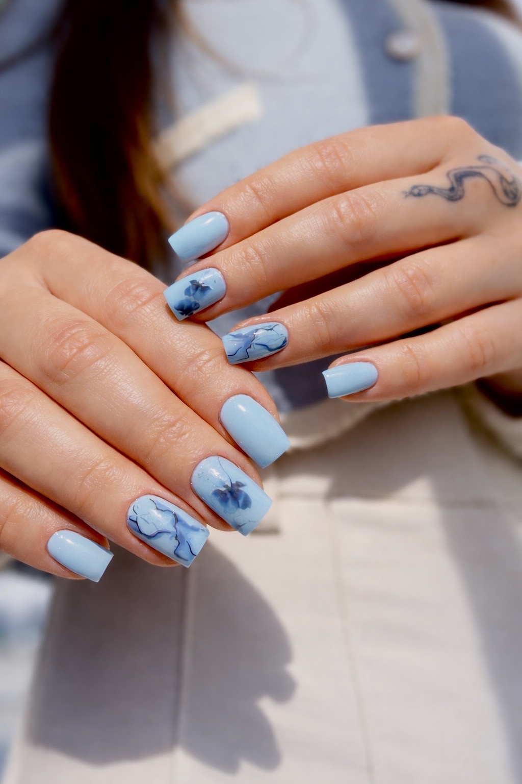 Lichtblauwe nagels met donkerblauwe bloemen als nail art